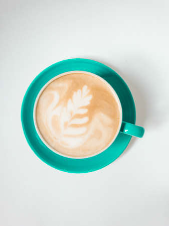 Top view. Hot coffee latte art on green cup isolated on white background.の写真素材