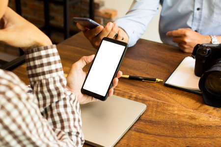 Newsletter concept Hand of two young man checking message box on digital mobile phone blank copy...