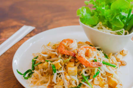 Stir Fried Rice Noodle with Prawns with  Bean sprouts in dish ,thai food on wood