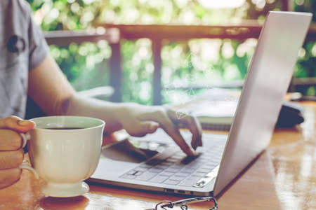 newsletter concept Hand of businesswoman holding cup of coffee and checking message box on digital...