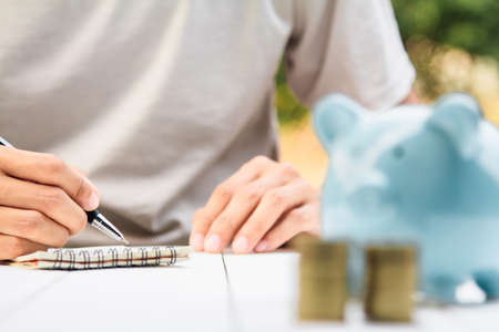 businessman Writing paper and using calculator Calculating bonus (Or other compensation) to...