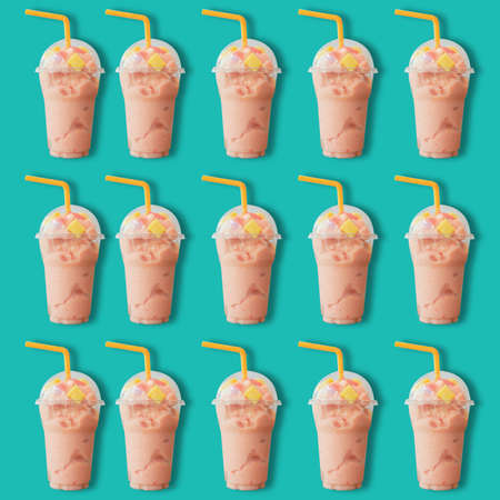 Freshness yogurt milk Strawberry smoothie in  plastic glass pattern on green pastel backgroundの写真素材