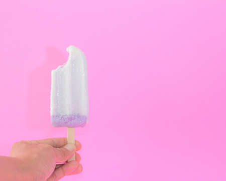 woman hand holding Taro flavor ice cream sticks on pink background. copy space for your textの写真素材