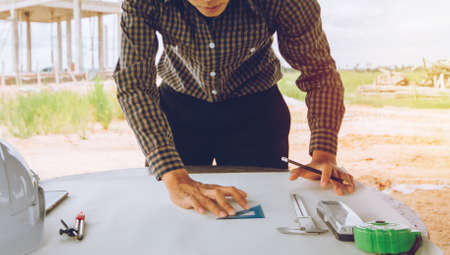 Concept architects,Asian engineer holding pen drawing and design Sketching Structure On the desk...