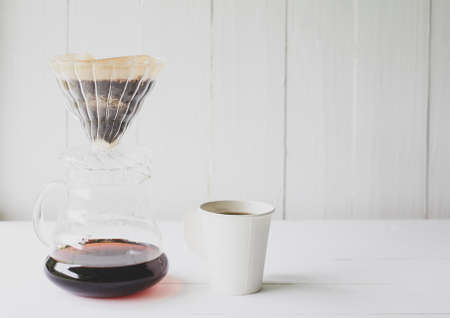 coffee brewing equipment and cup on white table wooden bar counter.の写真素材