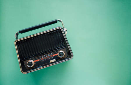 Retro style old  boombox radio from 1950s, 1960s  on green pastel paper background and Vintage tone style filter photoの写真素材