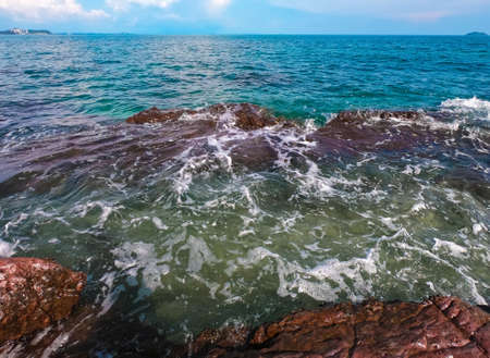 aqua sea water surface waves white Red rocks on white sandy beaches and clouds  natural blue sky....