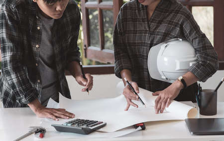 Concept architects, Two Engineer holding pen pointing equipment architects On a blueprint in the office.Selective Focusの写真素材