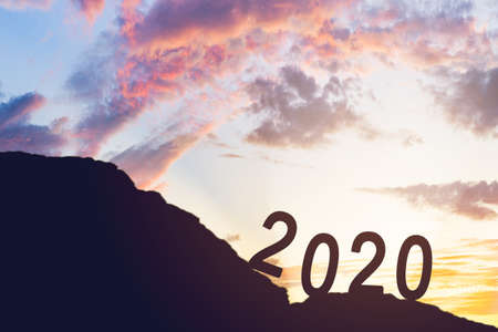 Happy New Year 2020.  number 2020 silhouette is slope mountain hiking hill  with sky cumulus cloud and sunset.go  the goal and successの写真素材