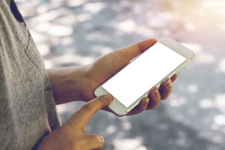 Newsletter concept hand of Asian woman checking message box on digital mobile phone outdoor. Mockup image blank white screen の写真素材