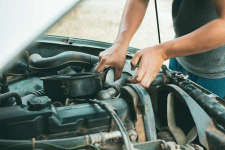 Young mechanic working use a wrench and fixing old car  