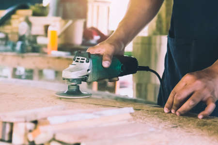 Carpentry is using an electric sander, to smoothen the wood texture. Small business woodworkingの写真素材