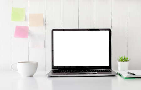 Digital technology Laptop muck up blank white screen and flower pot book, note paper,coffe cup on white table ,Home interior or office backgroundの写真素材