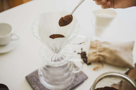 Close up. roasted coffee on a stainless spoon, with professional of barista pour Roasted coffee for...