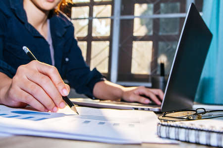 Asian young business woman of student holding a pen writing letter on paper and white mock up screen...