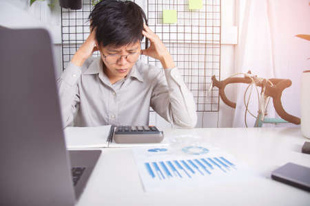 The man of businessman sitting stress with data graph work  er on the table  working at home office and backgroundの写真素材