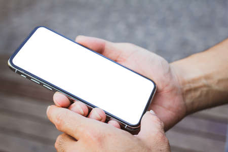 Close up of men hands holding touching mobile phone with blank copy space for your text message in...