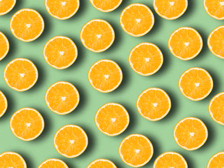 Fresh juicy whole and sliced orange on green pastel background. Fruit patternの写真素材