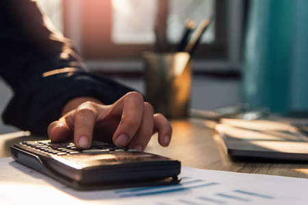 businessman hand using calculator Calculating bonus(Or other compensation) to employees to increase productivity, work from home, quarantine . Selective Focusの写真素材