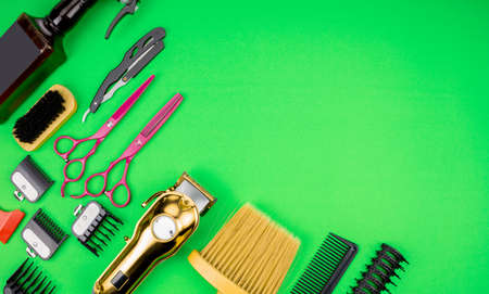 Hair clippers, razors, combs, brushes, haircut accessories, on a green paper background, leave space for the text.の写真素材