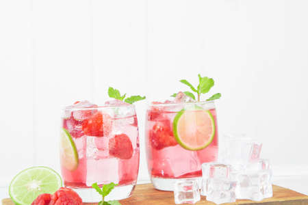 Homemade Raspberry cocktail iced in a glass with slice lemon, on top leaves of mint on wood bar. at homeの写真素材