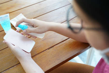 women Cleaning mobile phones with alcohol disinfectant spray germs, coronavirus Covid-19