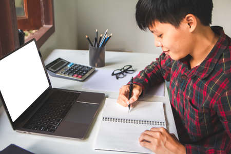 smiling people using pencil writing notebook paper learning and researching course tutor education, online on technology personal computer laptop with calculator, glasses Are sitting on the workplace.の写真素材