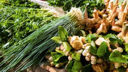 Ginger, galangal, lemongrass, coriander, kaffir lime leaves, spring onion Assorted fresh vegetables on the table for sale in the fresh vegetable market.の写真素材