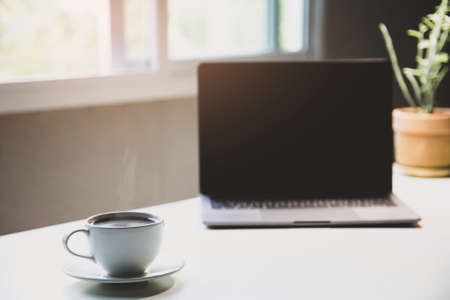 White of aroma coffee cup on the table with laptop ready to work for drink caffeine working home office in the morning, Energy drink before starting work concept. close upの写真素材