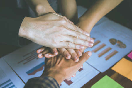 Group Asian business people put their hands together. Stacking hands.Unity mutually beneficial...