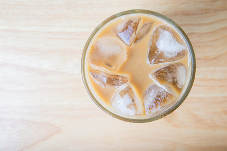 Top view Iced coffee with the bubble in the cup on wooden table.の写真素材
