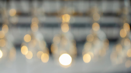 Blurred image of glass hanging at a bar drinking a drink. Bright lights in a restaurant. Abstract background.の写真素材