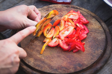 Close-up, slicing or slicing fresh tomatoes on wooden chopping board, preparing seasoning and cooking.の写真素材