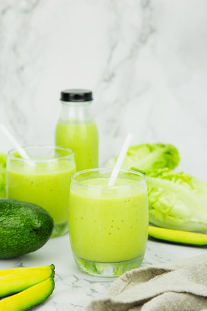 Avocado and green cos salad blended in a glass and bottle, healthy drinking water.  vertical photoの写真素材