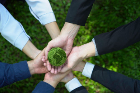 Hand of business teamwork, Holding earth in hands. Reducing Global Warming Environment Collaborate to create a green business, preserving the world in the future. Top viewの写真素材