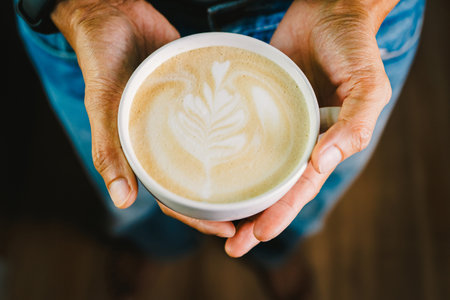 Clos up, Hand people holding the coffee cup and the joy of enjoying a homemade latte coffee.