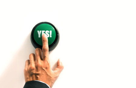 person presses the green button to confirm agreement, signaling approval and acceptance of a decision in voting or selection process.の写真素材