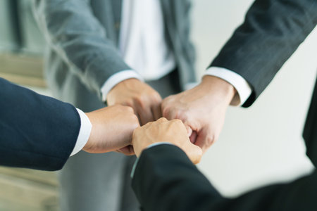 united team raises clenched fists in determination, working together to overcome challenges push forward toward business success and shared goals.の写真素材