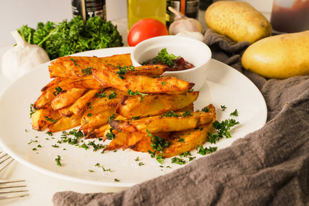 baked potatoes with paprika and garlic, topped with fresh parsley and rich tomato sauce an irresistible homemade dish served fresh from the oven.の写真素材