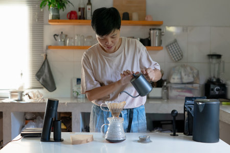 Asian people making coffee for dripping hot coffee into the cup with equipment, tool brewing at kitchen homeの写真素材