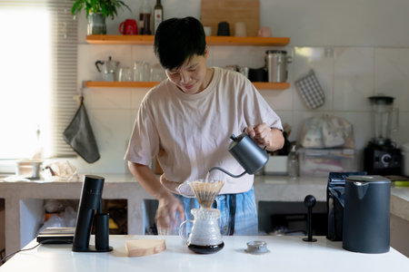 Asian people making coffee for dripping hot coffee into the cup with equipment, tool brewing at kitchen homeの写真素材