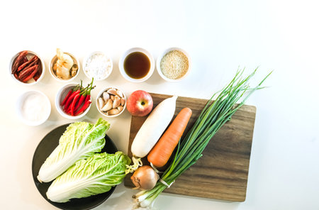 Thai style kimchi ingredients neatly arranged on a cream table ready for healthy cooking showcasing fresh vegetables and spices top view.の写真素材
