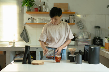 Asian people making coffee by dripping hot coffee into the cup and tasting the sweetness of coffee in the morning with equipment, tools in kitchen at homeの写真素材