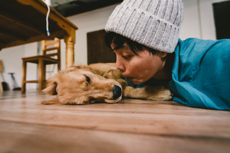 A real Asian man takes a selfie with a year-old golden retriever. The dog is licking its owner's face. People and fun playing together looking happily at the camera at home. Pet and personの写真素材