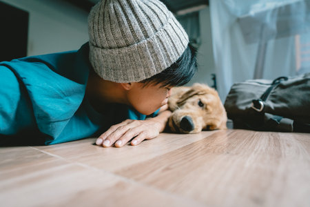 A real man takes a selfie with a year-old golden retriever. The dog is licking its owner's face. Smiling people and fun playing together looking happily at the camera at home. Pet and personの写真素材