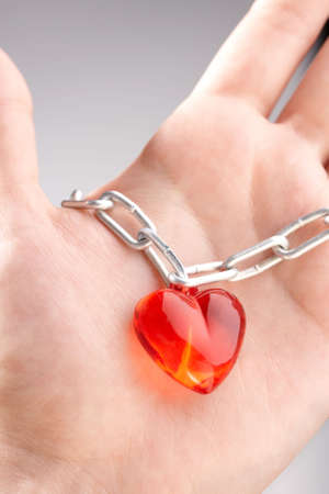 Heart on a chain wound on a palm