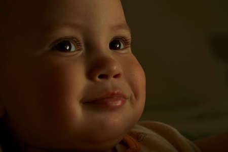 A smiling child on a dark background