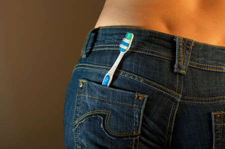 The bottom part of a body of the girl in jeans with a tooth-brush in a pocketの写真素材