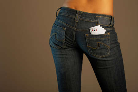The bottom part of the girl in jeans with four cards in a pocketの写真素材