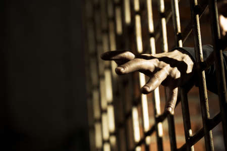 Human hand through a prison cell in the conclusionの写真素材
